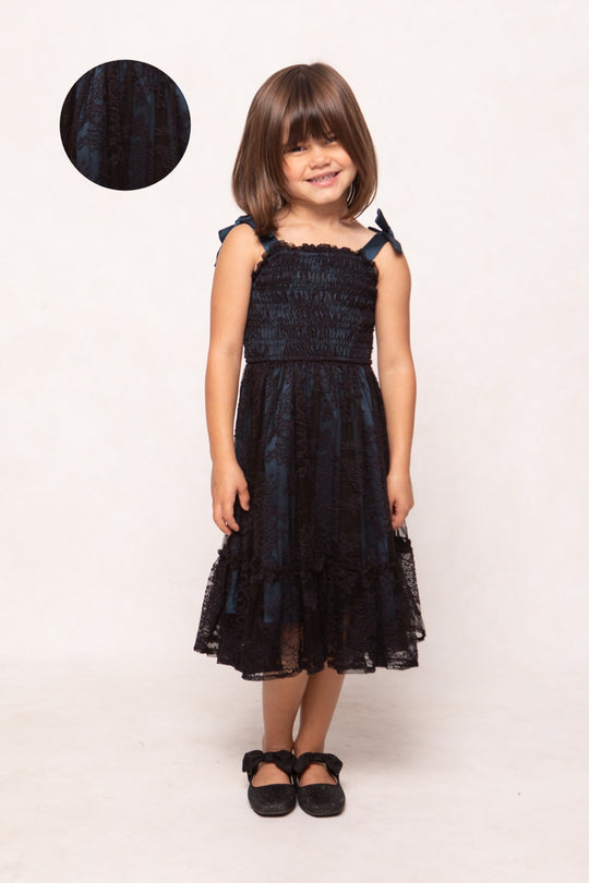 Young girl wearing a black lace dress on a white background