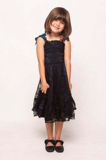 Young girl wearing a black lace dress on a white background