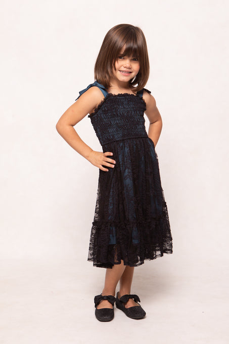 Young girl wearing a dark blue dress on a white background