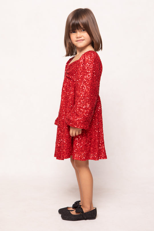 Young girl wearing a red dress with a white background