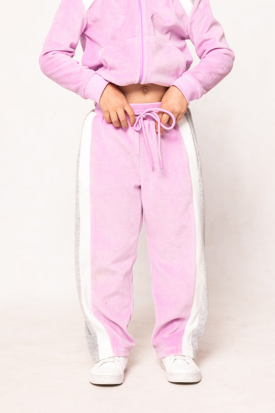 child in a pink sweatsuit against a white background