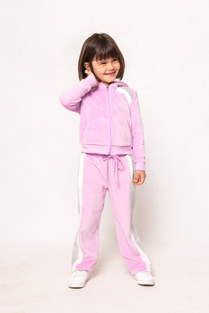 child in a pink sweatsuit against a white background