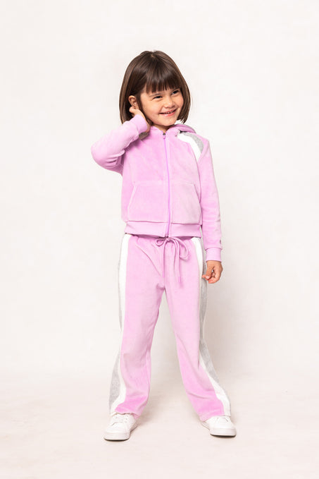 child in a pink sweatsuit against a white background