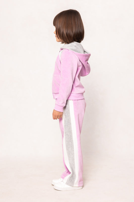 child in a pink sweatsuit against a white background