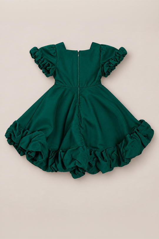 The Mini Kendy Dress in Emerald by Ivy City Co is a green organza dress with short ruffled flutter sleeves and a full skirt with ruffled edges, shown from the back with its visible zipper, laid flat on a neutral background.