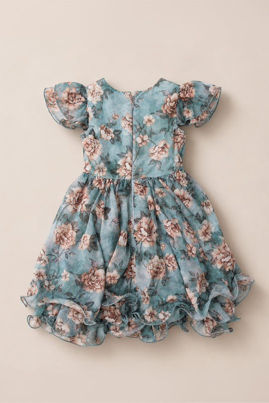 The Mini Lisette Dress in Rose Dusk by Ivy City Co is a blue floral dress for young girls, designed with short puff sleeves, a ruffled hem, and a back zipper. Adorned with an allover pink and white flower pattern, it’s the perfect charming choice for a junior bridesmaid at a fall wedding.