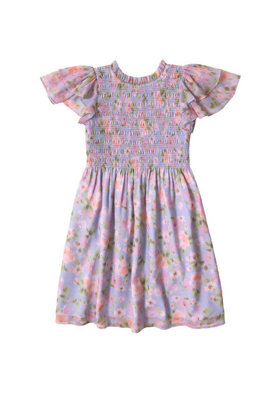 The Mini Lottie Dress in Vibrant English Garden by Ivy City Co is a girls’ midi dress with ruffled sleeves, a smocked bodice, and a pastel floral print in pink, green, and purple on light purple.
