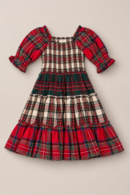 The Mini Madeline Dress in Mixed Plaid by Ivy City Co features puffed sleeves and a tiered skirt in a variety of red, green, and white plaid patterns. With its charming smocked bodice, this dress offers a festive and classic look—perfect as a Christmas dress for holiday celebrations.
