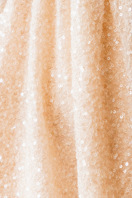 close up fabric shot of cream colored sequin dress