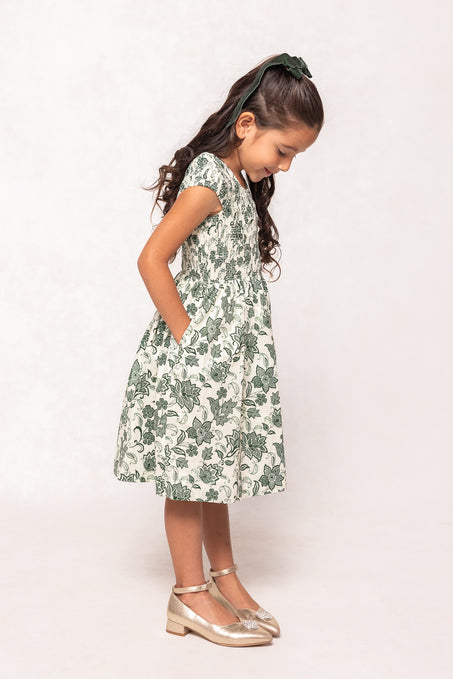 Young girl wearing a floral dress on a white background
