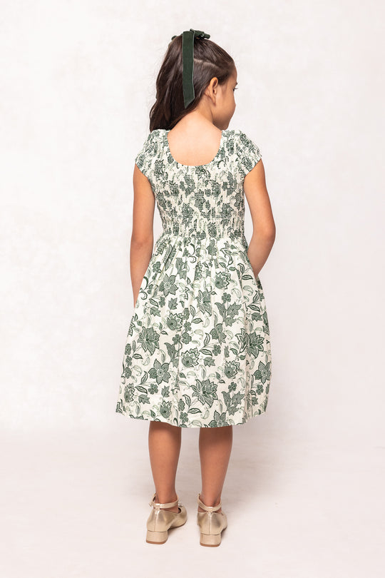 Woman wearing a floral dress with a plain background