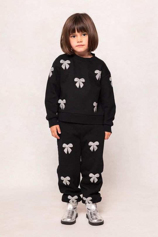 Child in a black sweatsuit against a background