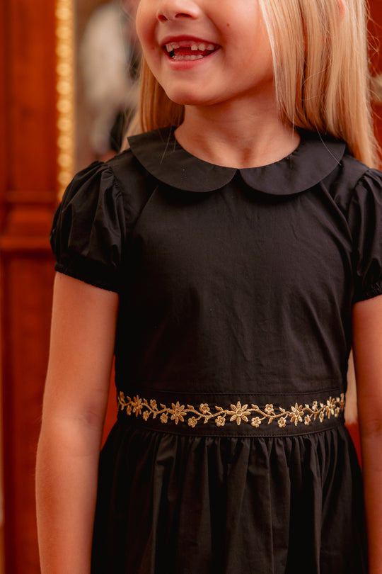 close up of a little girl in a black dress