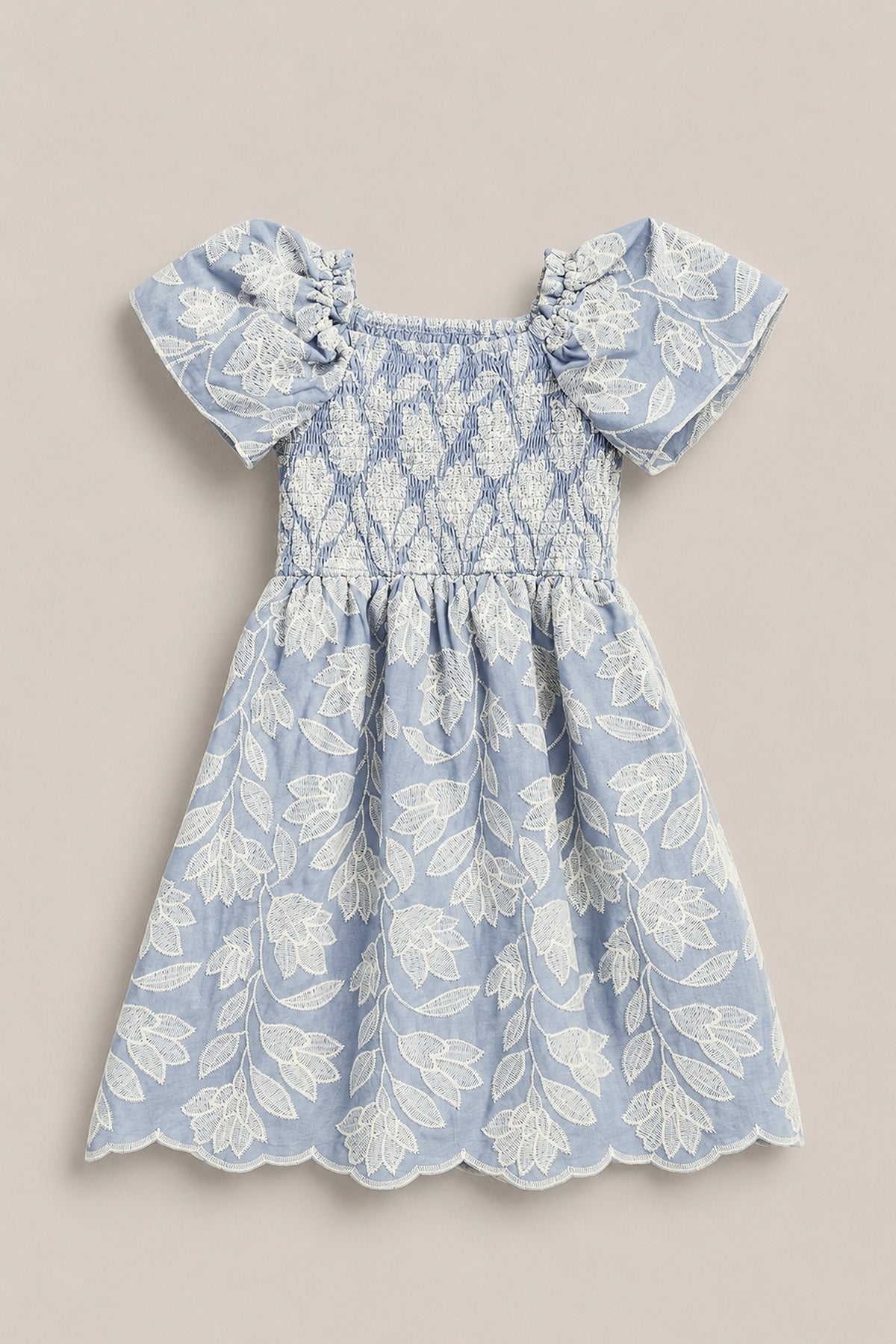 The Mini Ophelia Dress in Mosaic Embroidery by Ivy City Co features a light blue hue, white mosaic embroidery, puffed sleeves, smocked bodice, and scalloped hems. Shown laid flat on a neutral background. Perfect for Mom and Me matching looks.