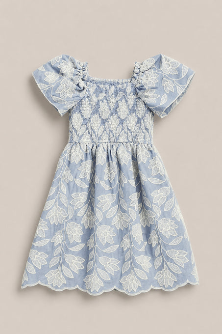 The Mini Ophelia Dress in Mosaic Embroidery by Ivy City Co features a light blue hue, white mosaic embroidery, puffed sleeves, smocked bodice, and scalloped hems. Shown laid flat on a neutral background. Perfect for Mom and Me matching looks.