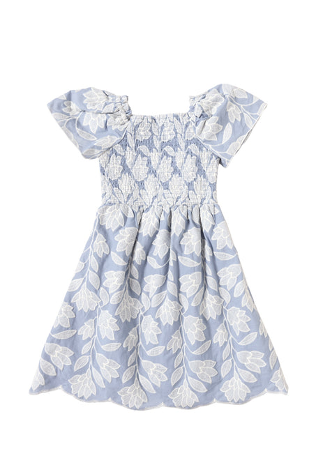 The Mini Ophelia Dress in Mosaic Embroidery by Ivy City Co features a light blue hue, smocked bodice, ruffled sleeves, white floral patterns, and a flared skirt with mosaic white leaf and flower embroidery—perfect for Mom and Me matching.