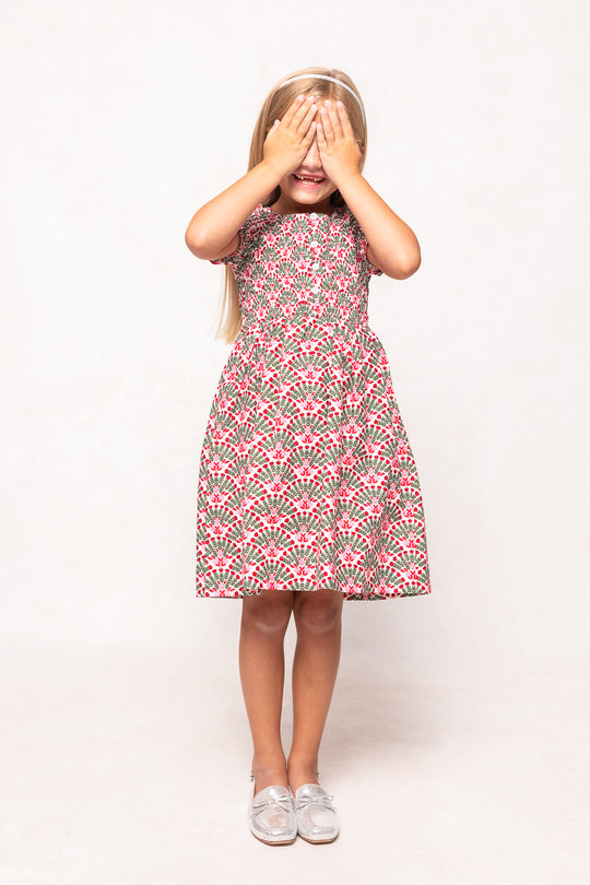 Young girl wearing a pink floral dress on a white background
