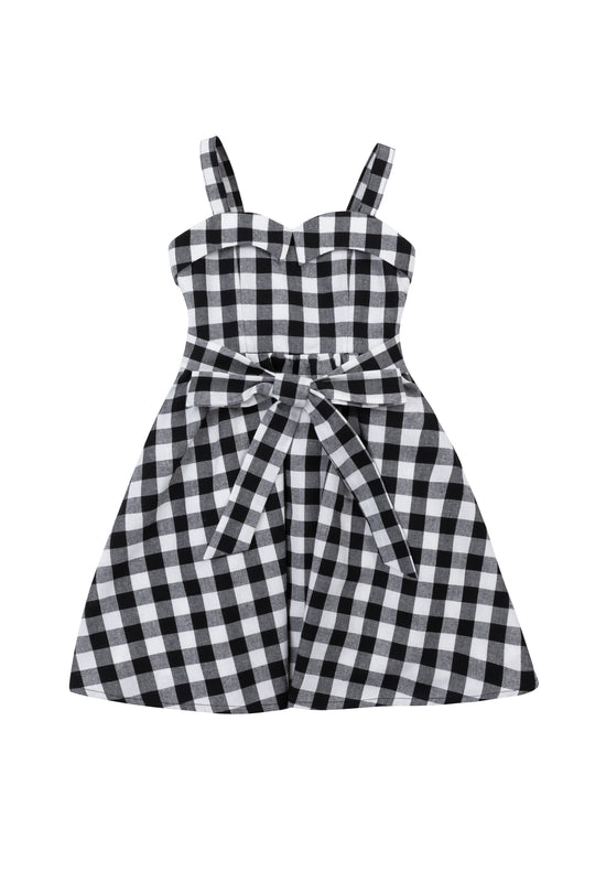 The Ivy City Co Mini Patty Dress in Black Gingham features a sleeveless design, sweetheart neckline, fitted bodice, spaghetti straps, and a bow-tied waist belt, shown laid flat on a white background.