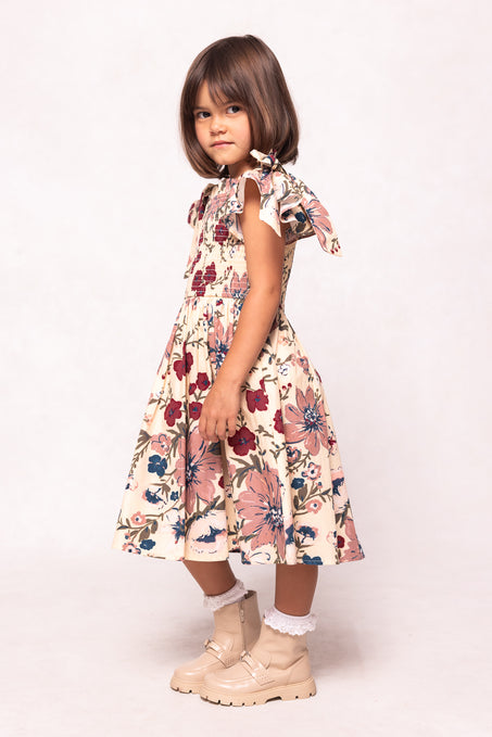 Young girl wearing a floral dress with ruffled sleeves on a white background