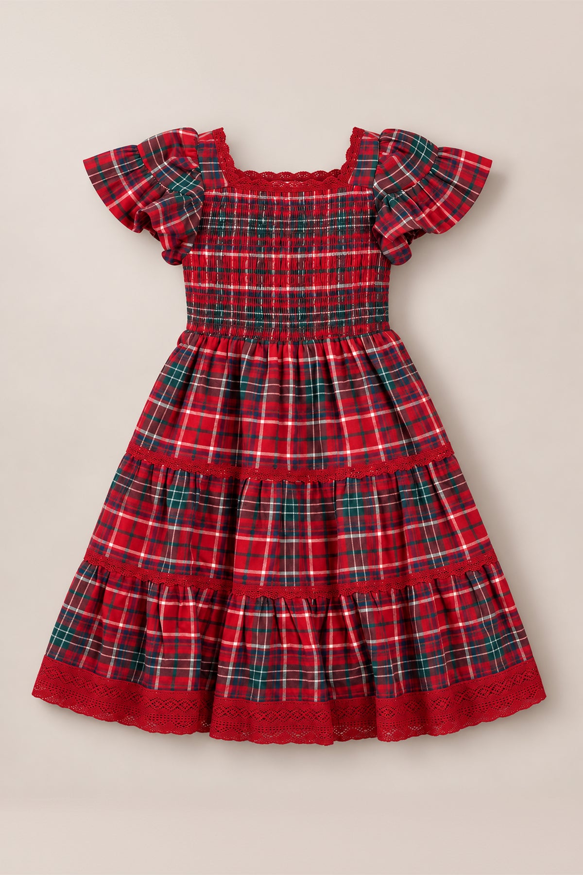 The Mini Rosario Dress in Christmas Cheer Plaid by Ivy City Co features a red and green plaid design with short puff sleeves, a smocked bodice, square neckline, tiered skirt, and delicate lace trim on the sleeves and hem. Displayed on a neutral background, this charming girls’ holiday dress is perfect for festive celebrations.