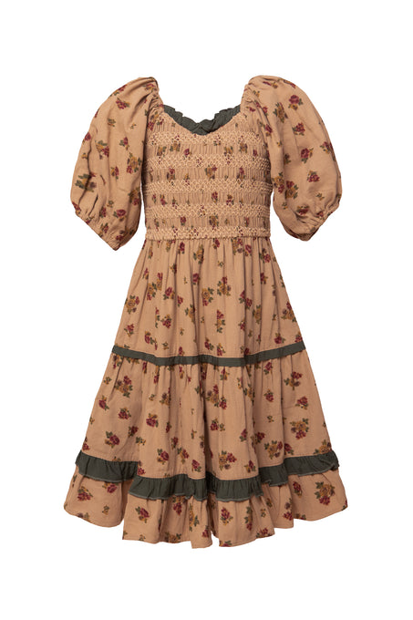 The Mini Roselyn Dress in Desert Blossom by Ivy City Co is a vintage-inspired, 100% cotton girls midi dress in peach with puff sleeves, a smocked bodice, floral print, and dark green trim at the neckline, sleeves, and tiered skirt.