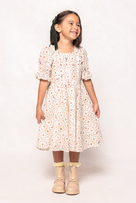 Young girl wearing a floral dress with ruffled boots on a white background