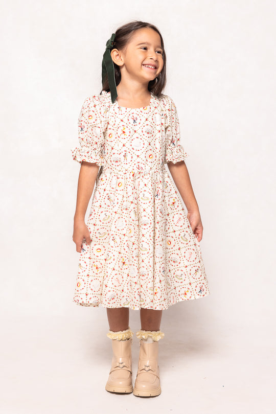 Young girl wearing a floral dress with ruffled boots on a white background