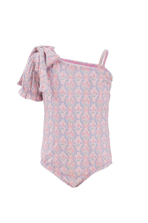 The Ivy City Co Mini Sailor One Piece in Raquel Pink Floral is a stylish girls’ swimsuit featuring a pink floral design, one thin strap, and a large ruffled bow detail for an adorable look.