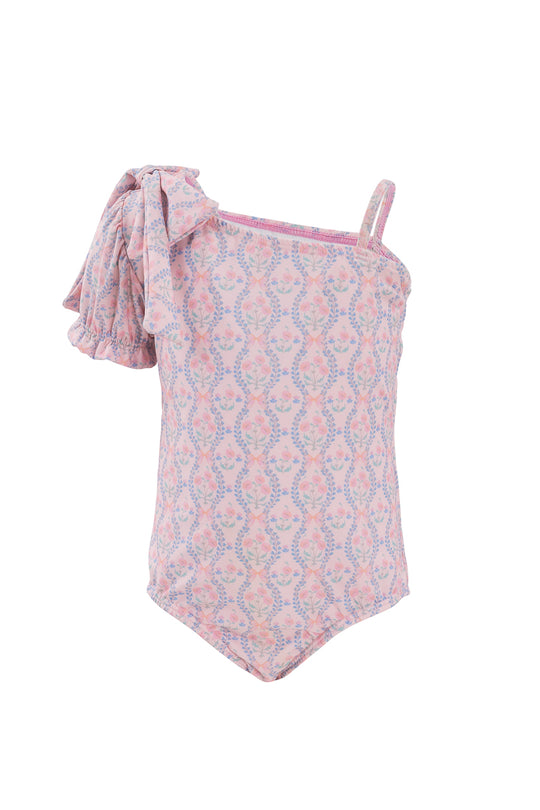 The Ivy City Co Mini Sailor One Piece in Raquel Pink Floral is a stylish girls’ swimsuit featuring a pink floral design, one thin strap, and a large ruffled bow detail for an adorable look.