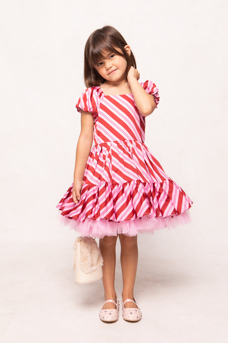 Young girl wearing a red and white striped dress on a white background