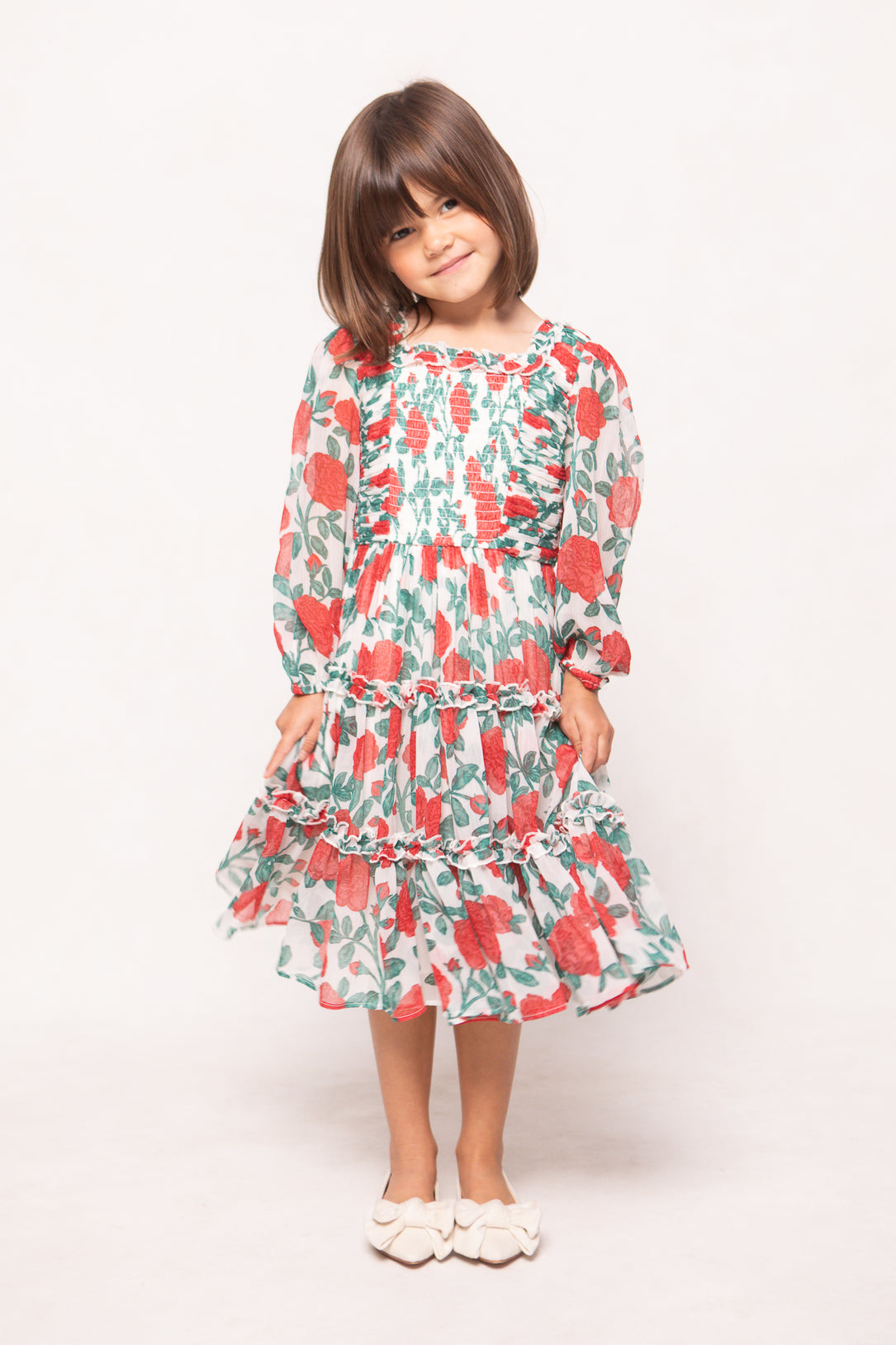Young girl wearing a floral dress on a white background