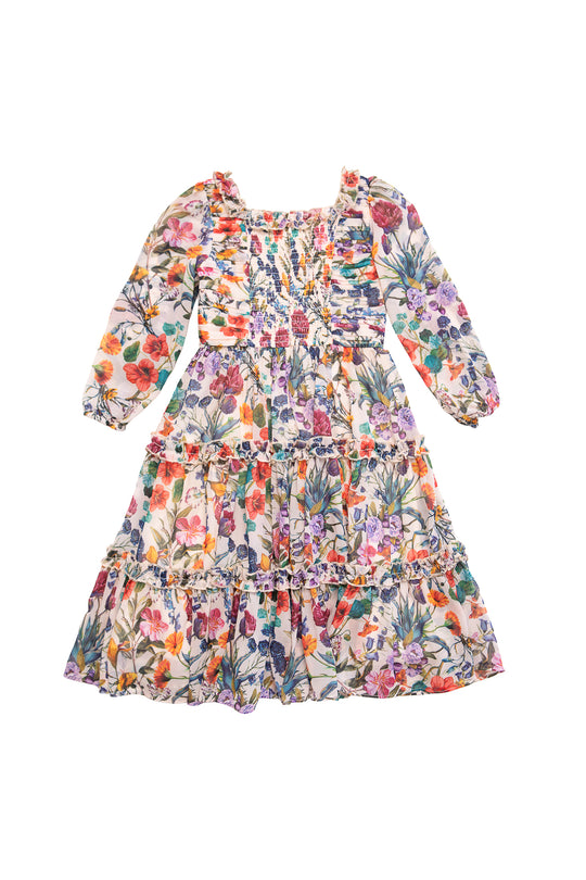 The Mini Selena Dress in Vivid Meadow by Ivy City Co is a long-sleeved, ankle-length girls dress with a square neckline, vibrant floral print on white, gathered tiered ruffle skirt, and playful ruffled details.