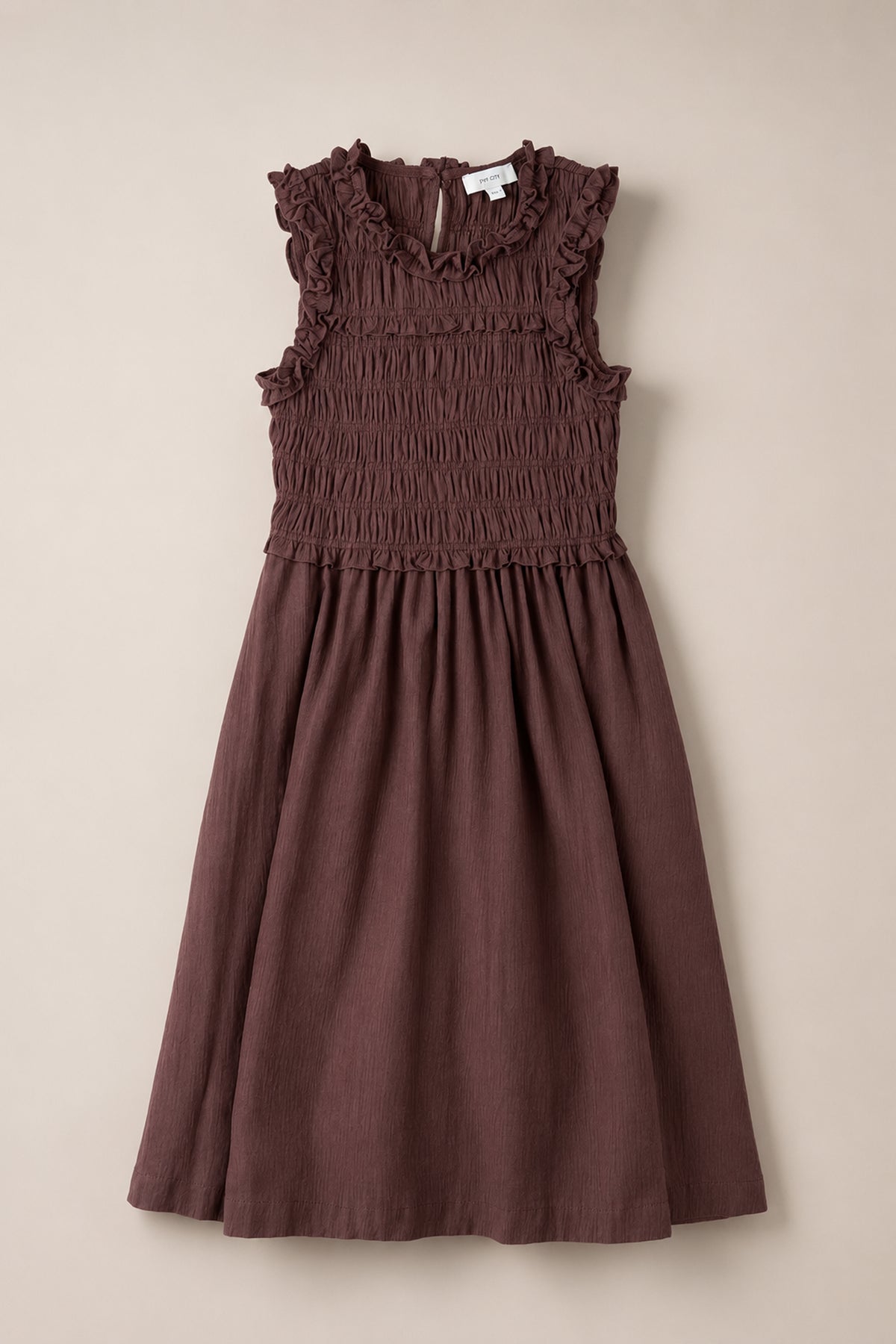 Sleeveless, knee-length Teen Simone Dress in a warm cocoa color from Ivy City Co, featuring ruffle details on the shoulders and neckline, a gathered smocked bodice, and convenient pockets.