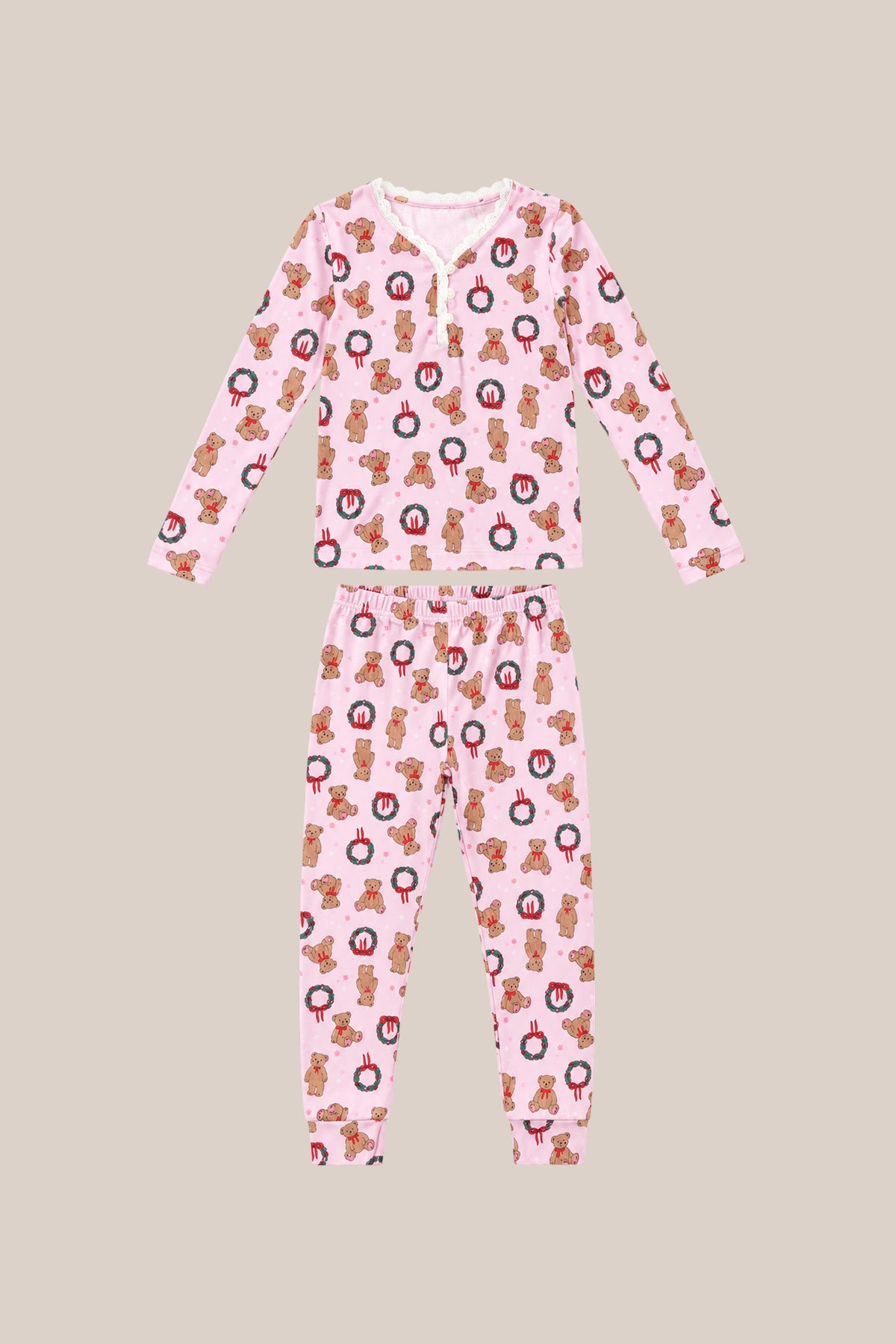 The Mini So Soft Henley Pajama Set in Teddy Bear Wreaths by Ivy City Co is a two-piece pink pajama set with long sleeves and pants, featuring teddy bear wreath prints, laid flat on a beige background.
