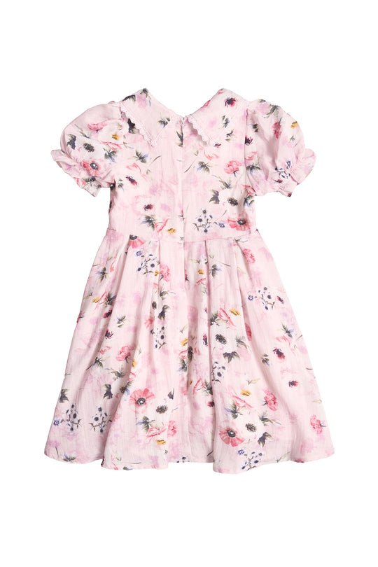 The Mini Sophia Dress in Roselyn Pink by Ivy City Co is a girls’ knee-length, short-sleeved dress with a floral print, puffed sleeves, gathered waist, and back zipper—ideal for matching mommy and me looks. Shown on a white background.