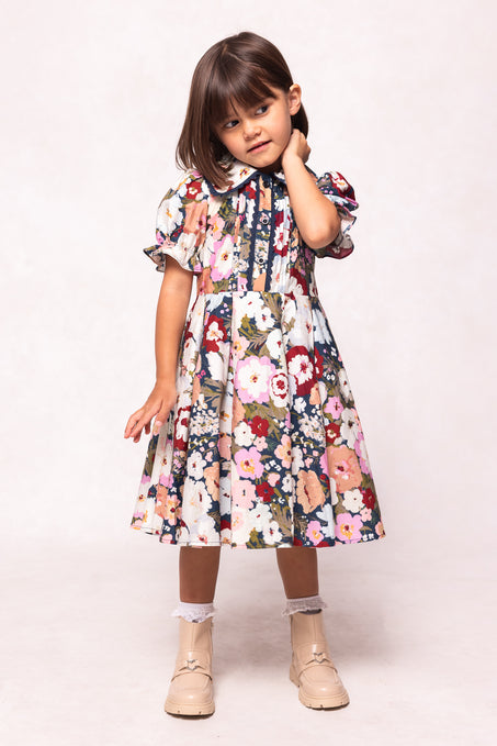 Young girl wearing a floral dress on a white background