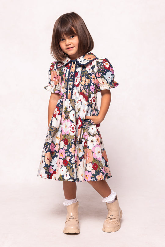 Young girl wearing a floral dress on a white background