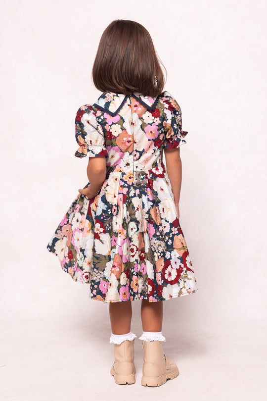 Back view of a person wearing a floral dress on a white background
