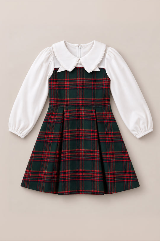 The Mini Tawny Dress in Evergreen Plaid by Ivy City Co features a red and green plaid skirt and bodice, crisp white long puffed sleeves, and a timeless white Peter Pan collar. Displayed on a neutral background, this charming dress is perfect for Christmas celebrations or any holiday portrait occasion.
