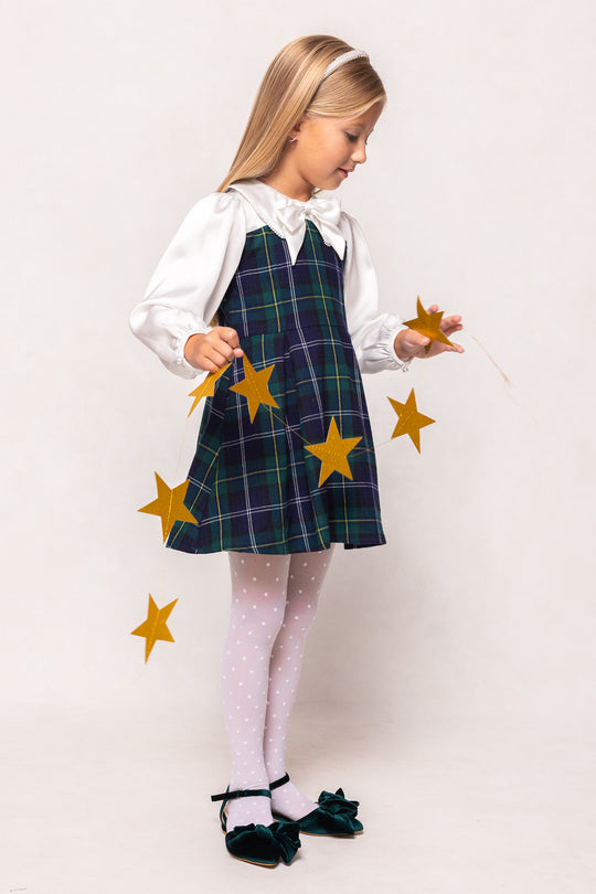 Young girl in a plaid dress with yellow stars on a white background