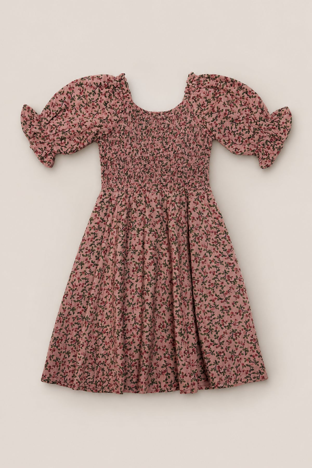 The Mini Teagan Dress in Mauve Woodland Floral by Ivy City Co features puffed short sleeves, a smocked bodice, and a flared skirt. This charming cotton dress showcases a delicate black woodland floral pattern throughout and is displayed laid flat on a neutral background.