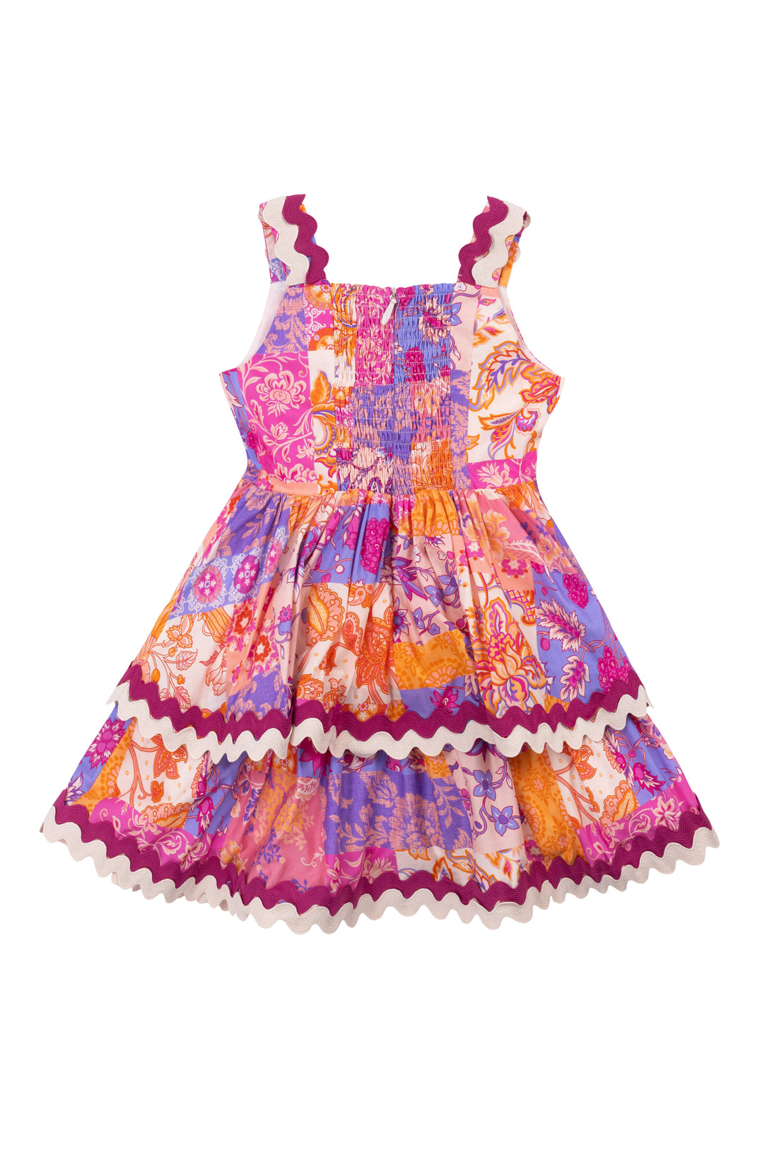 The Mini Tessa Dress in Pink Floral Tile by Ivy City Co is a sleeveless cotton knee-length dress for girls, featuring a colorful pink pattern, gathered elastic bodice, and wavy trim on the straps, waist, and hem.