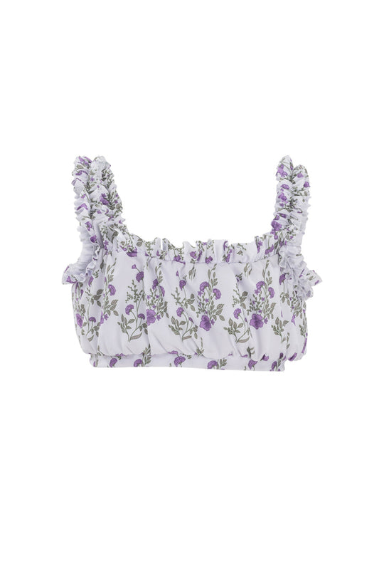 The Mini Thea Top in Maeve Floral by Ivy City Co is a white crop top for girls with ruffled straps and small purple flowers with green leaves, making it a stylish floral swim top.