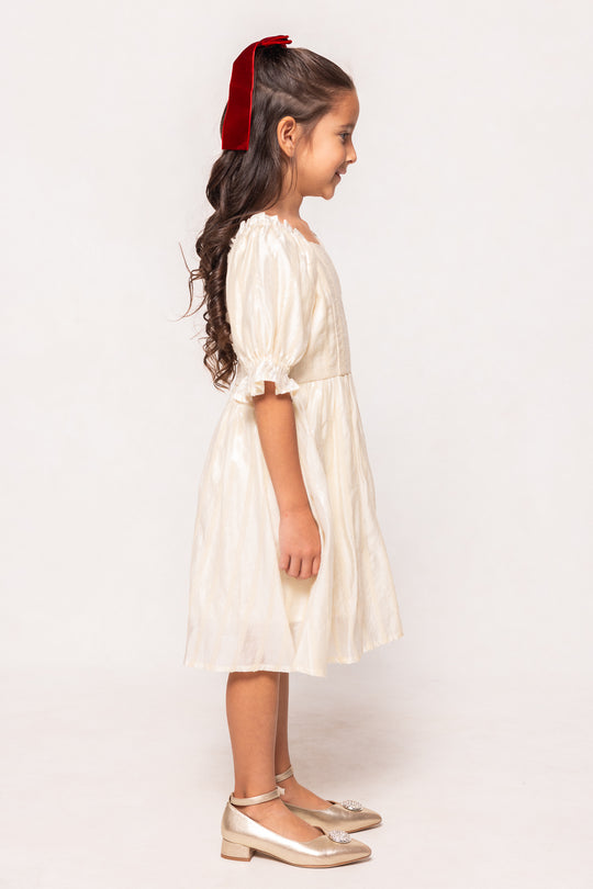 Young girl wearing a white dress with a red hairband on a white background