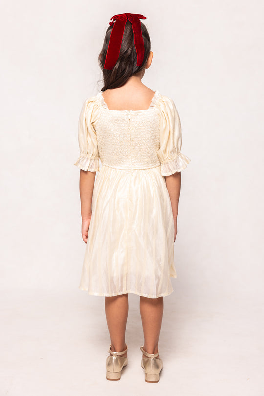 Woman wearing a white dress with puffed sleeves against a white background