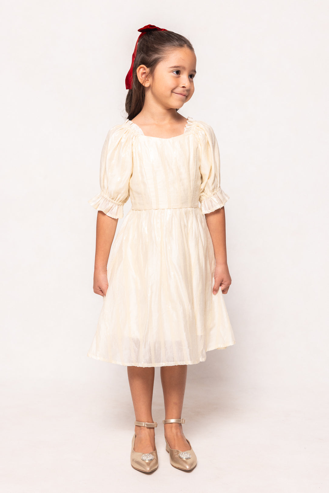 Young girl wearing a white dress with a plain background