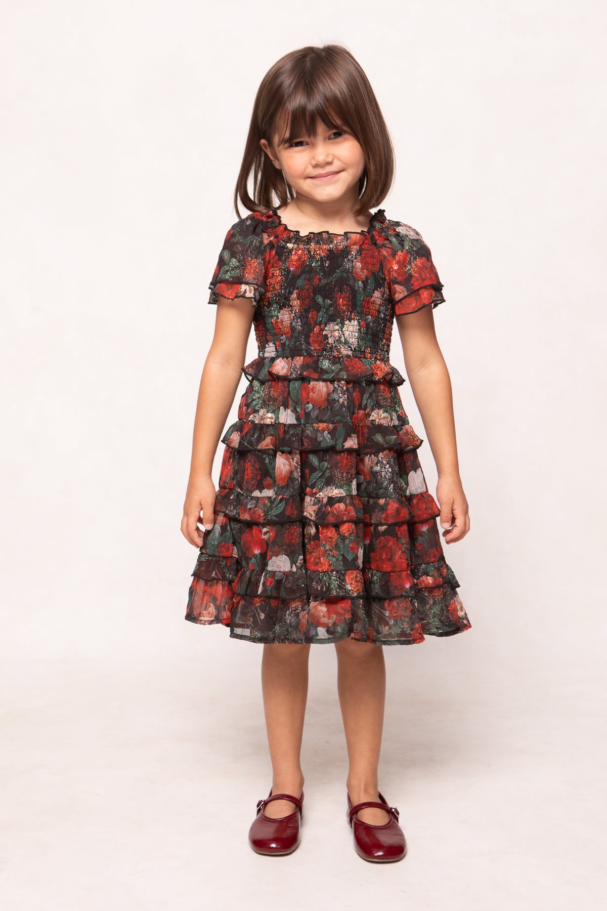 Young girl wearing a floral dress on a white background