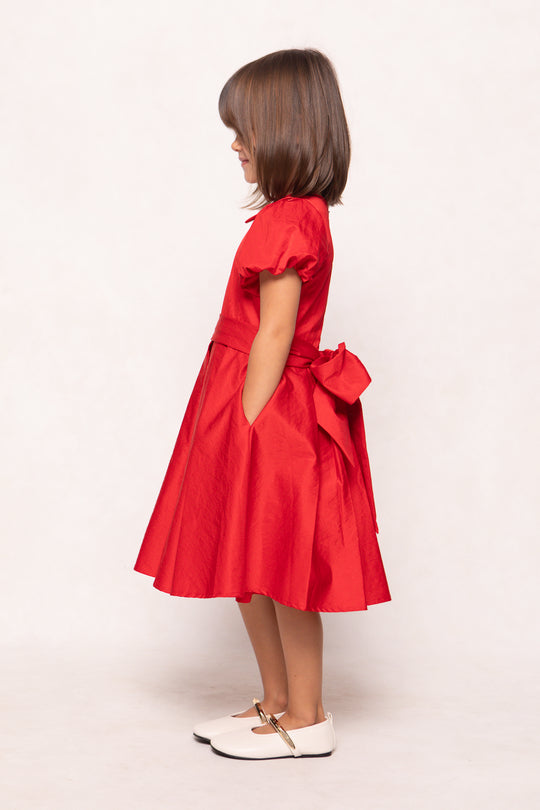 Red dress with a bow detail on a white background