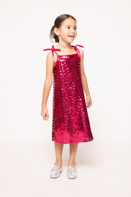 Young girl wearing a pink sequin dress on a white background
