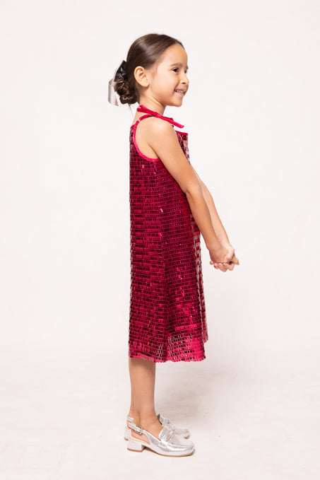 Young girl wearing a red sequin dress on a white background